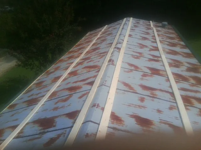 Rusted metal roof panels with new wood purlins before replacement — Storm Damage Roof Repair in Tilden by Roofing Brothers