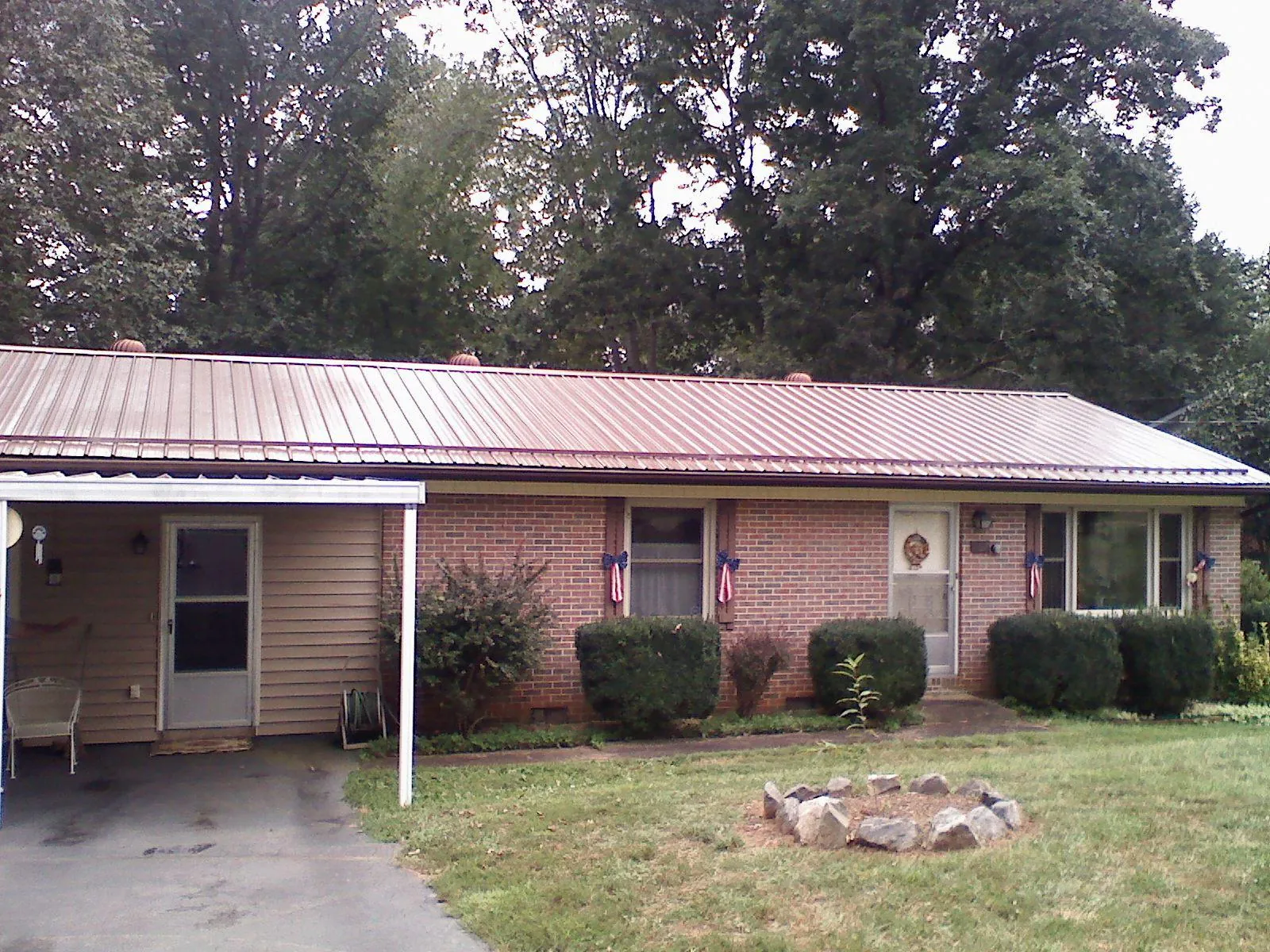 Bronze metal roof and carport on a brick ranch home — Roof Repair work by our crew in Tilden